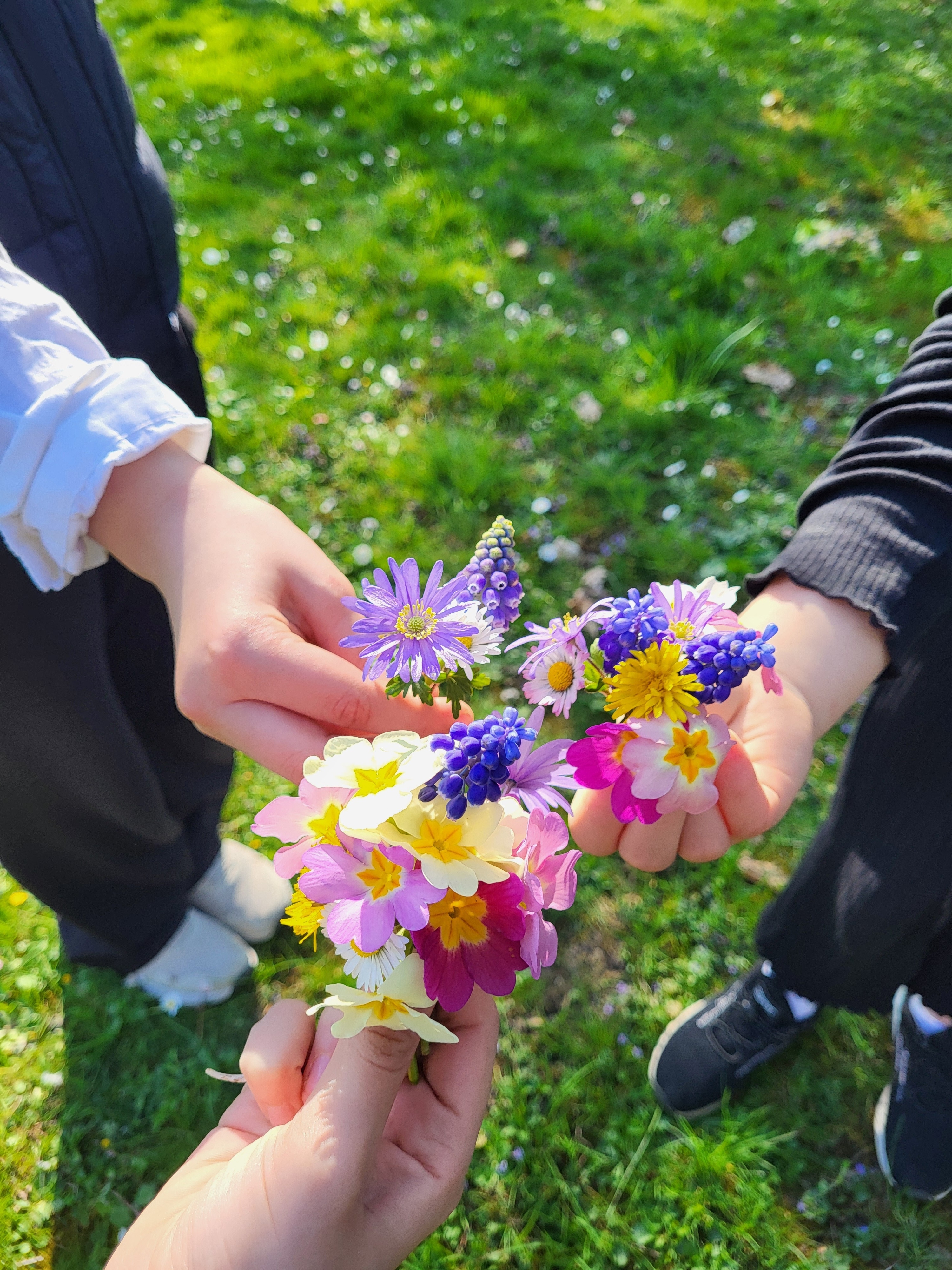 Bild von bunten Blumen die drei Kinder in den Händen halten